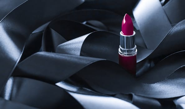 Purple lipstick on black silk background, luxury make-up and beauty cosmetics