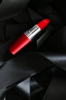 Red lipstick on black silk background, luxury make-up and beauty cosmetics