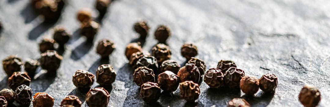 Black pepper closeup on luxury stone background as flat lay, dry food spices and recipe ingredients