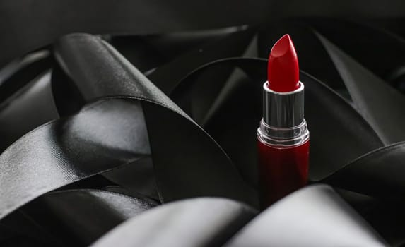 Red lipstick on black silk background, luxury make-up and beauty cosmetics