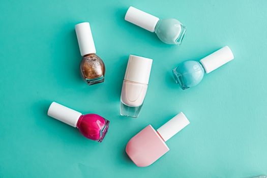 Nail polish bottles on green background, beauty branding