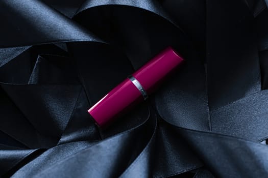 Purple lipstick on black silk background, luxury make-up and beauty cosmetics