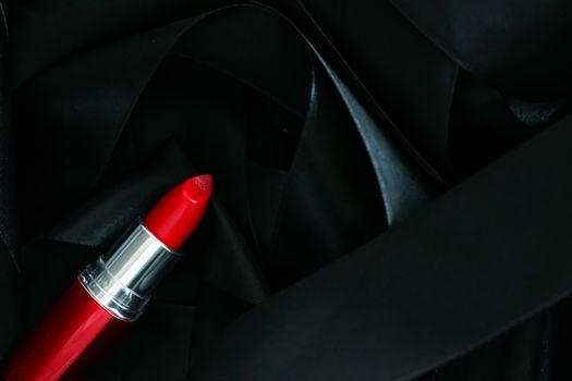 Red lipstick on black silk background, luxury make-up and beauty cosmetics