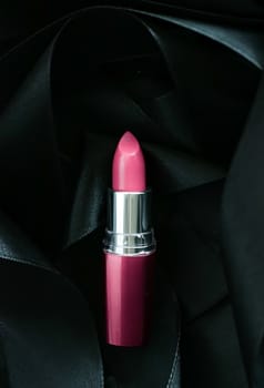 Pink lipstick on black silk background, luxury make-up and beauty cosmetics