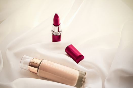 Cosmetic branding, glamour and skincare concept - Beige tonal cream bottle make-up fluid foundation base and red lipstick on silk background, cosmetics products as luxury beauty brand holiday design