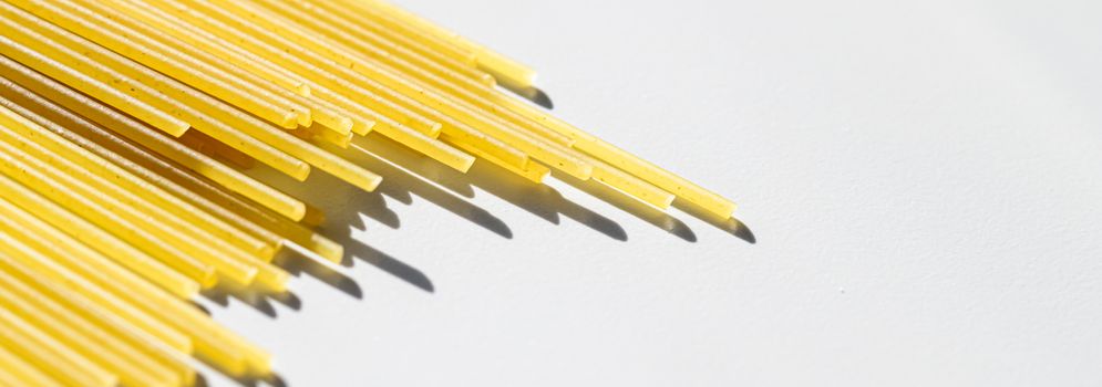 Uncooked whole grain spaghetti closeup, italian pasta as organic food ingredient, macro product and cook book recipes