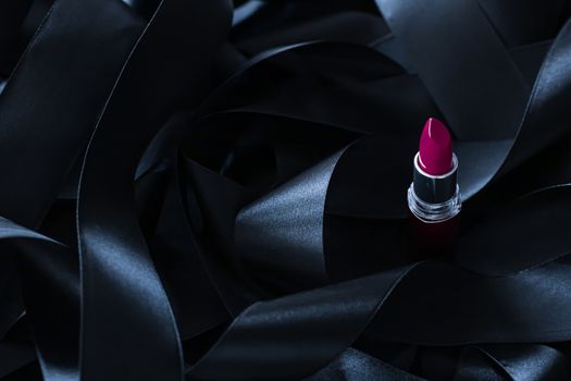 Purple lipstick on black silk background, luxury make-up and beauty cosmetics