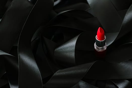 Red lipstick on black silk background, luxury make-up and beauty cosmetics