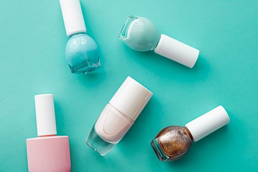 Nail polish bottles on green background, beauty branding