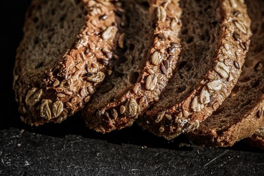 Fresh whole grain seeded bread, organic wheat flour, closeup slice texture as background for food blog or cook book recipes