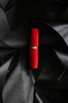 Red lipstick on black silk background, luxury make-up and beauty cosmetics