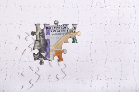 100 USD bill under Blank white puzzle jigsaw : economic crisis management concept