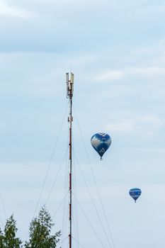 Minsk, Belarus - 10 September 2017: Two balloons, flying around the mast with receiving and transmitting equipment