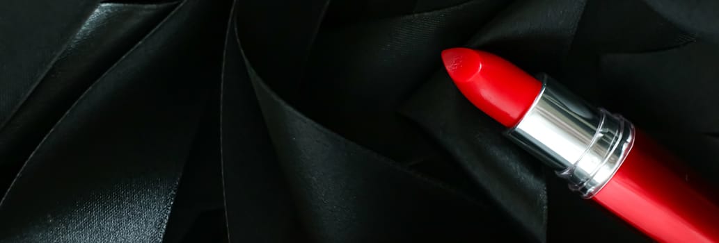 Red lipstick on black silk background, luxury make-up and beauty cosmetics