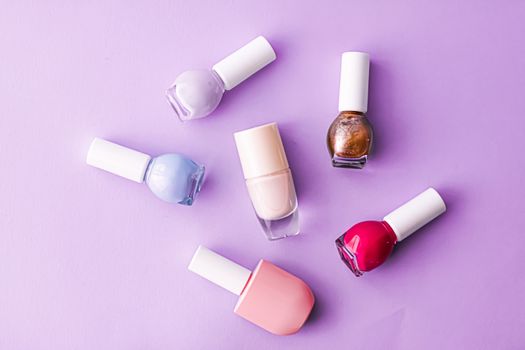 Nail polish bottles on purple background, beauty branding