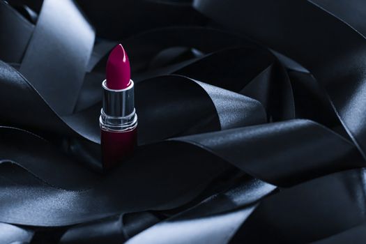 Purple lipstick on black silk background, luxury make-up and beauty cosmetics