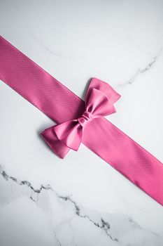 Birthday, wedding and girly branding concept - Pink silk ribbon and bow on marble background, girl baby shower present and glamour fashion gift decor for luxury beauty brand, holiday flatlay design