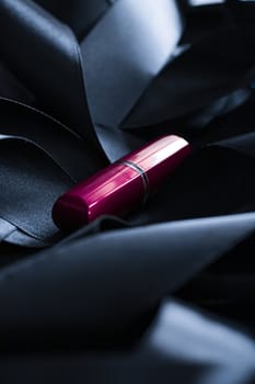 Purple lipstick on black silk background, luxury make-up and beauty cosmetics