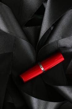 Red lipstick on black silk background, luxury make-up and beauty cosmetics