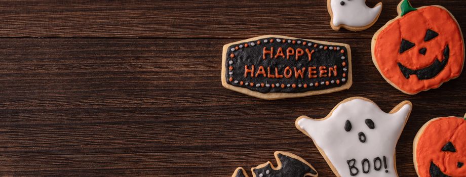 Top view of Halloween festive decorated icing gingerbread sugar cookies with copy space and flat lay layout.