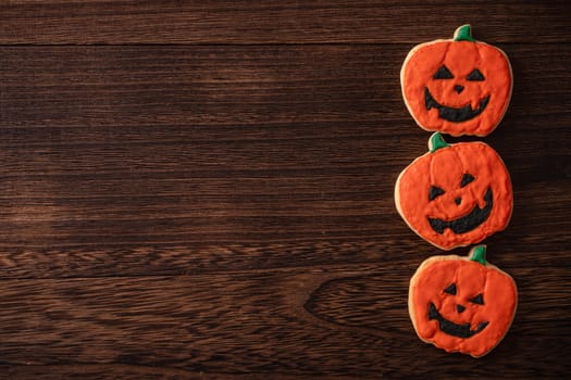 Top view of Halloween festive decorated icing gingerbread sugar cookies with copy space and flat lay layout.