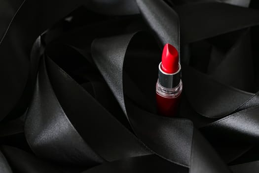 Red lipstick on black silk background, luxury make-up and beauty cosmetics