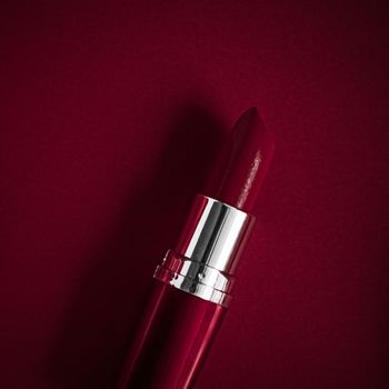 Cosmetic branding, glamour lip gloss and shopping sale concept - Luxury lipstick and silk ribbon on maroon holiday background, make-up and cosmetics flatlay for beauty brand product design