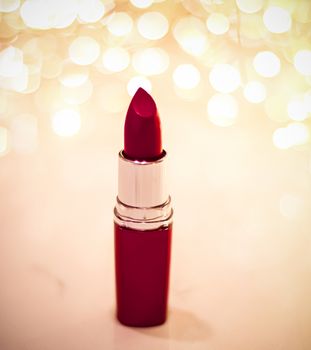 Cosmetic branding, sale and glamour concept - Dark red lipstick on golden Christmas, New Years and Valentines Day holiday glitter background, make-up and cosmetics product for luxury beauty brand