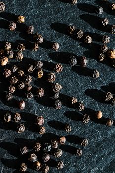 Black pepper closeup on luxury stone background as flat lay, dry food spices and recipe ingredients