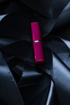 Purple lipstick on black silk background, luxury make-up and beauty cosmetics