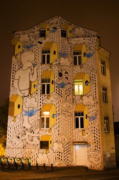 VILNIUS, LITHUANIA - OCTOBER 17, 2017: Mural on the building exterior, night and yellow lights