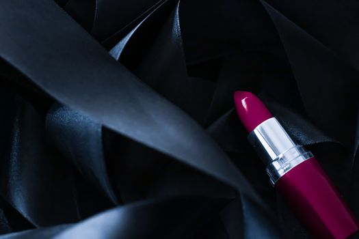 Purple lipstick on black silk background, luxury make-up and beauty cosmetics