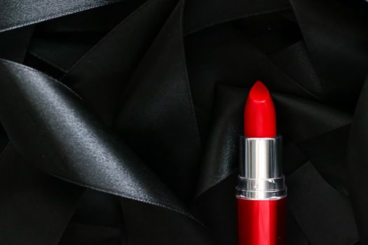 Red lipstick on black silk background, luxury make-up and beauty cosmetics