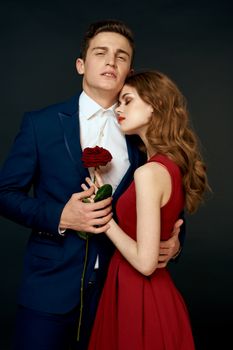 young couple hugs charm red rose relationship black background. High quality photo