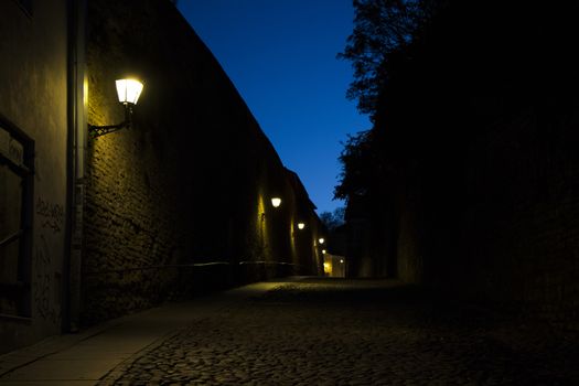 TALLINN, ESTONIA - OCTOBER 20, 2017: night street situation, street light and stone road.
