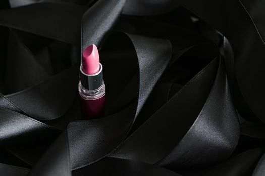 Pink lipstick on black silk background, luxury make-up and beauty cosmetics