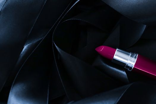 Purple lipstick on black silk background, luxury make-up and beauty cosmetics