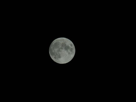 An amazing photography of the full moon over the city of Genova by night with a great clear sky in background and some stars