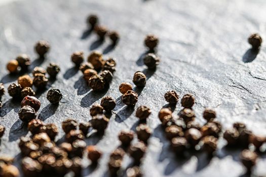 Black pepper closeup on luxury stone background as flat lay, dry food spices and recipe ingredients