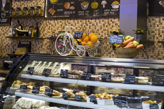 TBILISI, GEORGIA - MART 03, 2019: Coffee shop interior. Desserts, sweet food, fruits and graces text.