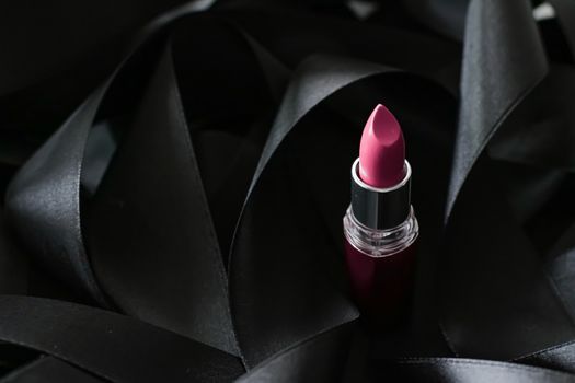 Pink lipstick on black silk background, luxury make-up and beauty cosmetics