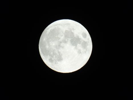 An amazing photography of the full moon over the city of Genova by night with a great clear sky in background and some stars