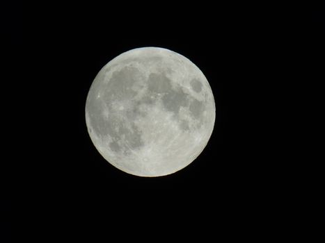 An amazing photography of the full moon over the city of Genova by night with a great clear sky in background and some stars