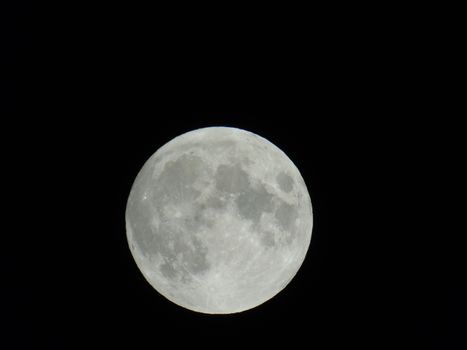 An amazing photography of the full moon over the city of Genova by night with a great clear sky in background and some stars