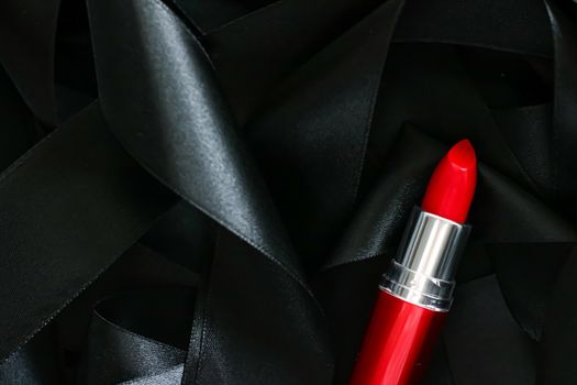 Red lipstick on black silk background, luxury make-up and beauty cosmetics