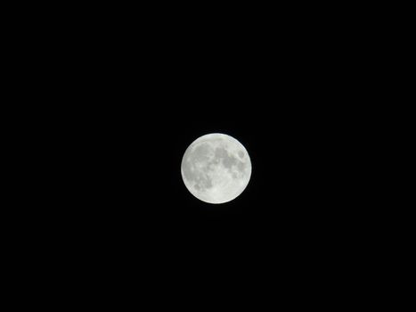 An amazing photography of the full moon over the city of Genova by night with a great clear sky in background and some stars