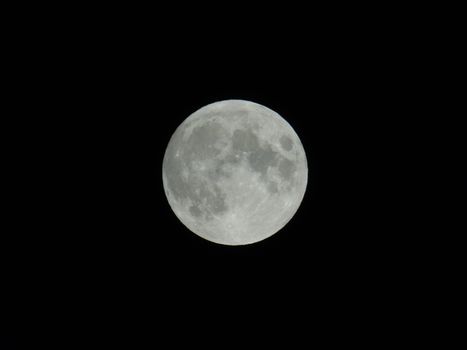 An amazing photography of the full moon over the city of Genova by night with a great clear sky in background and some stars