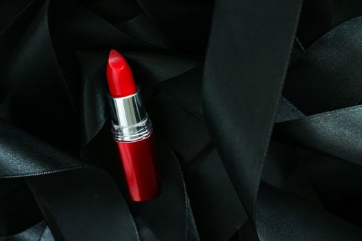 Red lipstick on black silk background, luxury make-up and beauty cosmetics