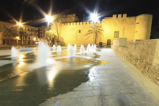 Elche, Alicante, Spain- October 22, 2020:Beautiful illuminated Altamira Palace and fountain in empty street at night in Elche, Alicante