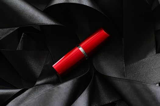 Red lipstick on black silk background, luxury make-up and beauty cosmetics